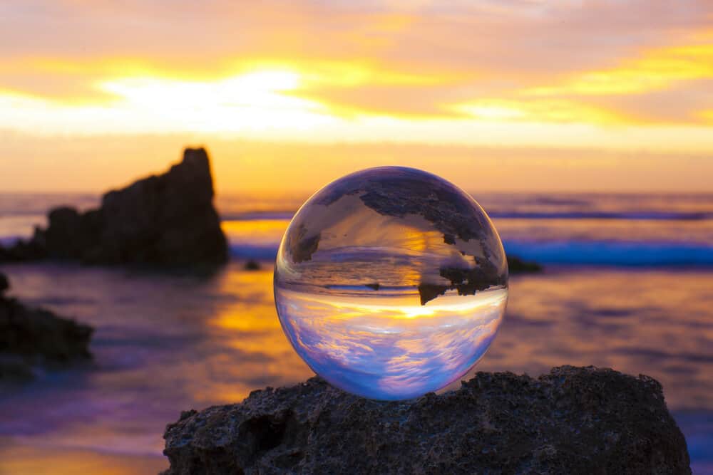 Image of a glass sphere on a rock near a body of water